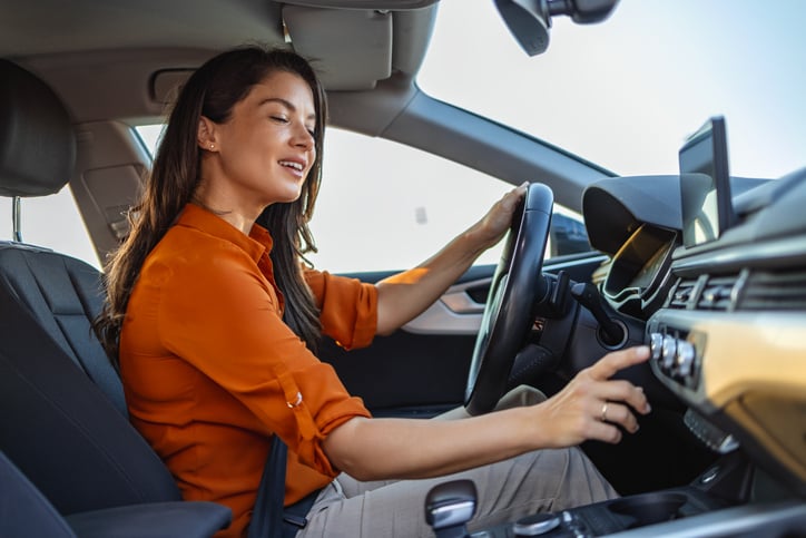 Vrouw zet airco aan in auto