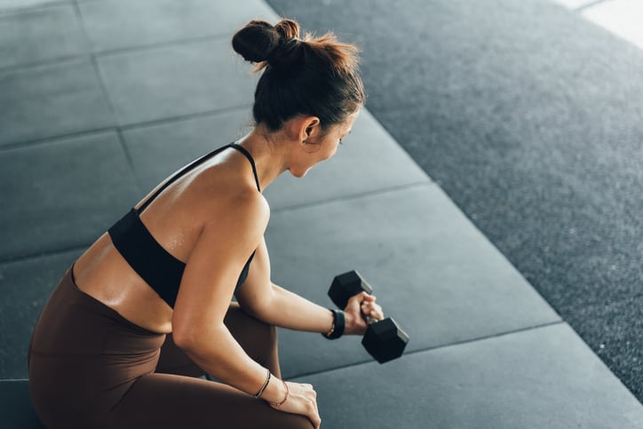 vrouw met gewicht in hand in sportschool