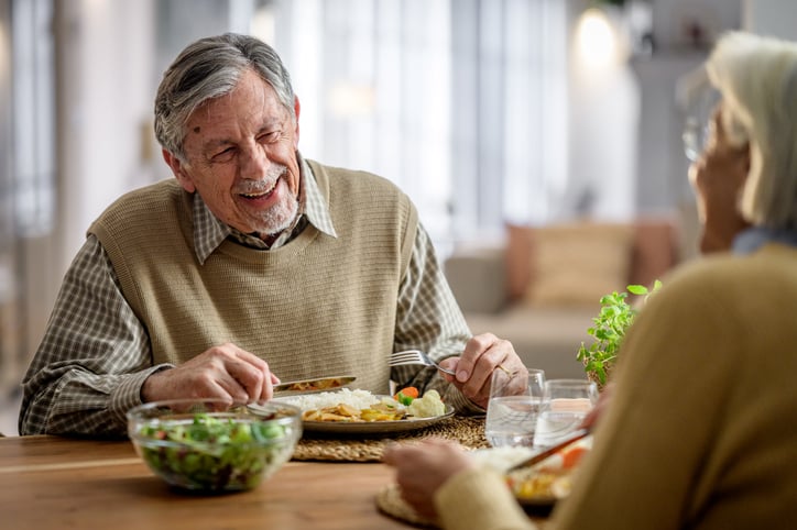 Oude man eet aan tafel