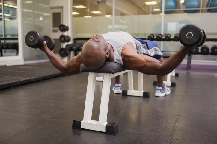 man doet dumbbell flyes