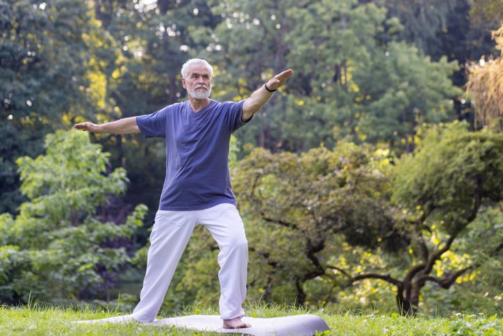 Man staat op mat buiten in pose