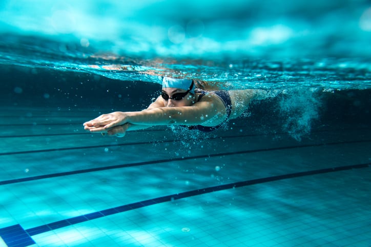Zwemmer duikt onder water in zwembad
