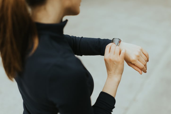 Vrouw meet hartslag tijdens het hardlopen met smartwatch