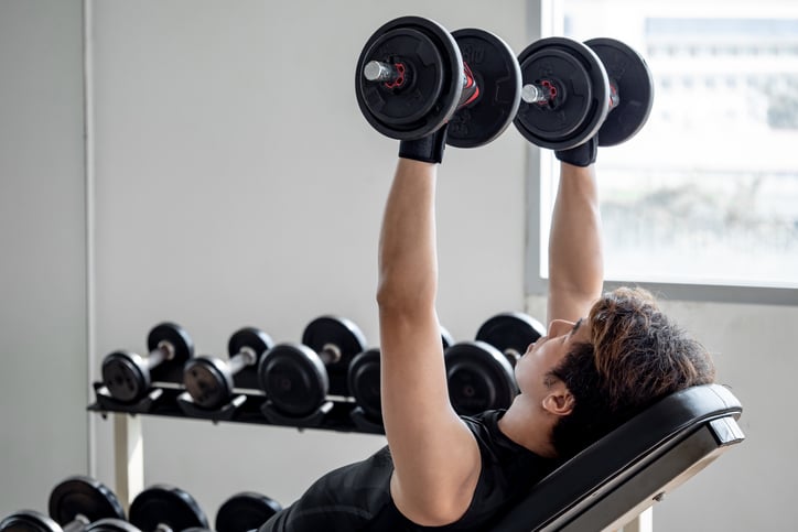 Man doet dumbell bench press