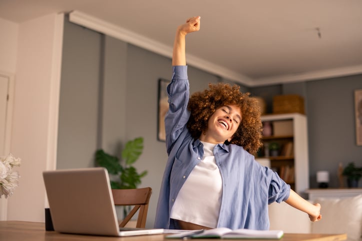 Vrouw rekt zich uit achter laptop
