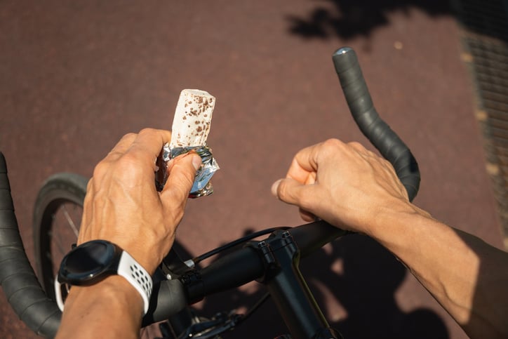 Man eet proteïne reep op fiets