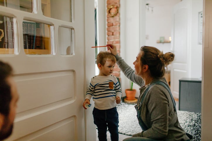 Moeder meet de lengte van kind op
