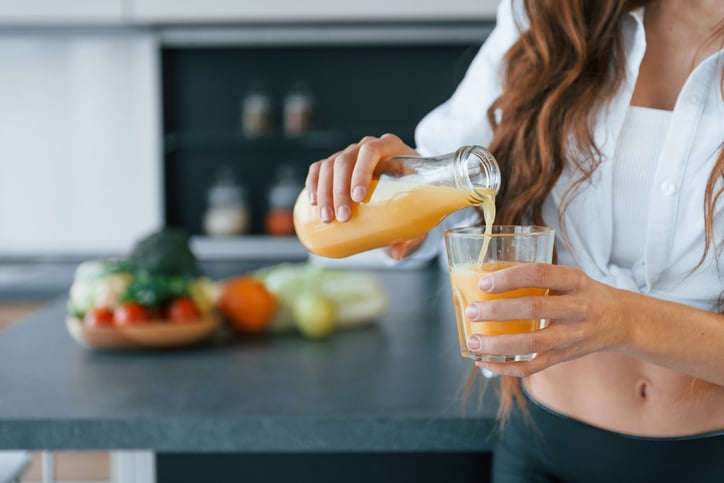 Vrouw schenkt wortelsap in glas