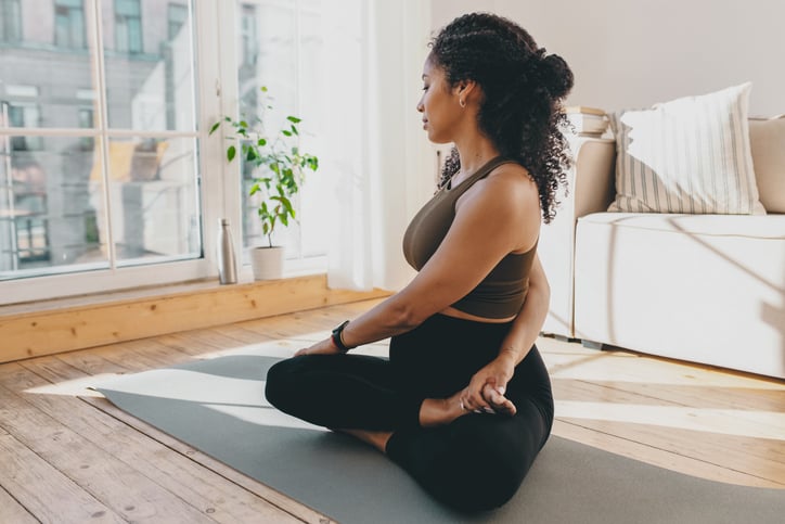 Vrouw doet yoga oefeningen op yoga mat