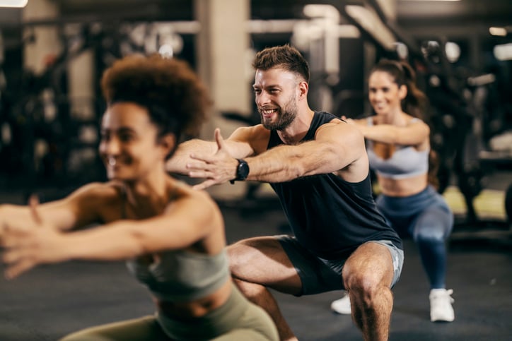 Groep met mannen en vrouwen aan het squaten