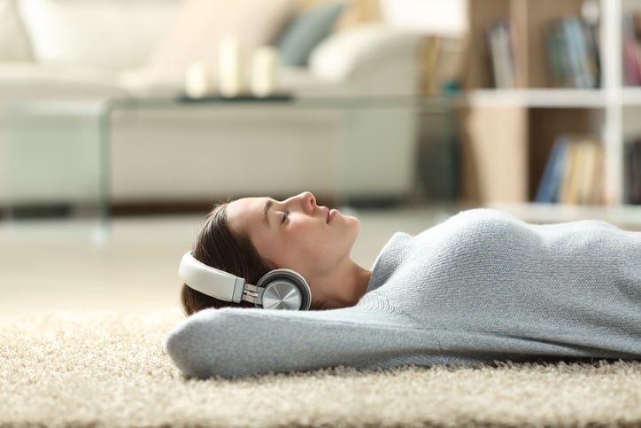 Vrouw ligt op grond muziek te luisteren