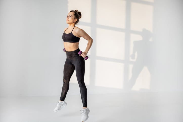 Vrouw doet jumping lunges met gewichten