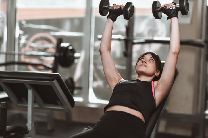 vrouw doet incline dumbbell press