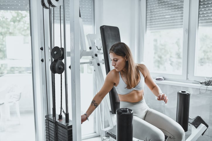 Vrouw traint benen in de sportschool