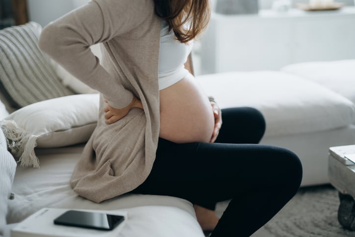 Zwangere vrouw wrijft over buik