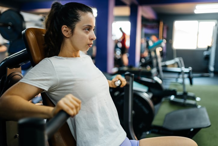 vrouw gebruikt chest press machine