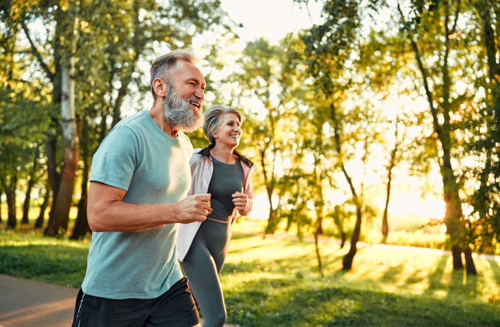 Man en vrouw lopen hard in het bos