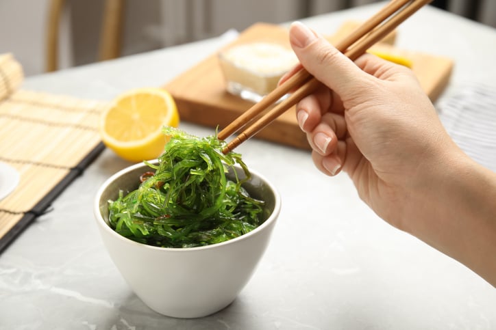Wakame wordt met stokjes vastgehouden