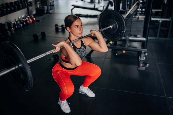 Vrouw doet front squat in de sportschool