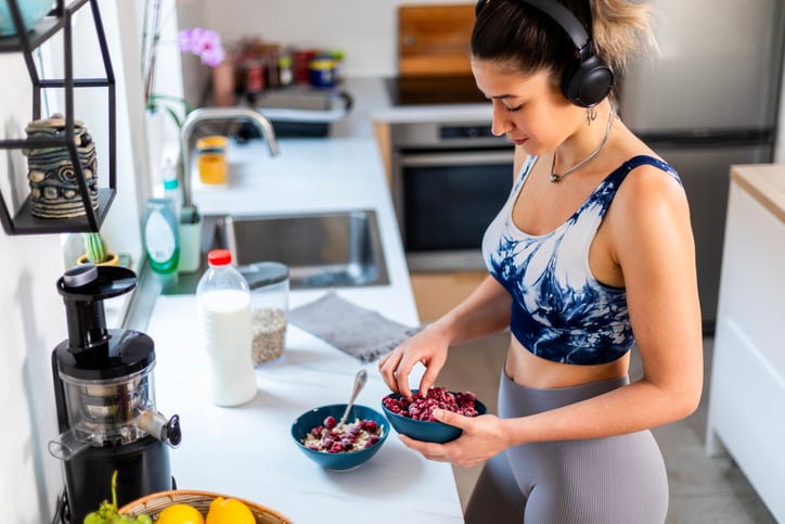 Vrouw maakt gerecht in de keuken in sport kleding