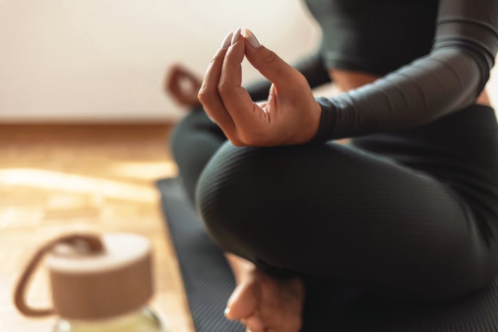 Vrouw zit rustig op een yogamatje