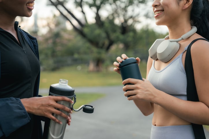Vrouwen genieten van eiwitshake in shakebeker