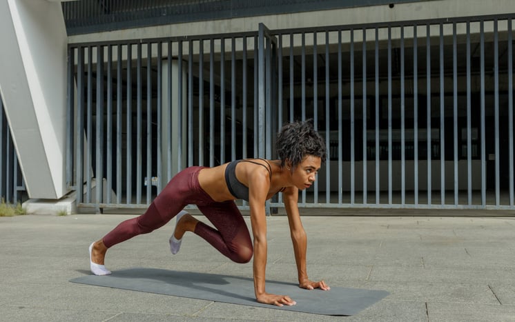 Sportende vrouw buiten op een yoga mat